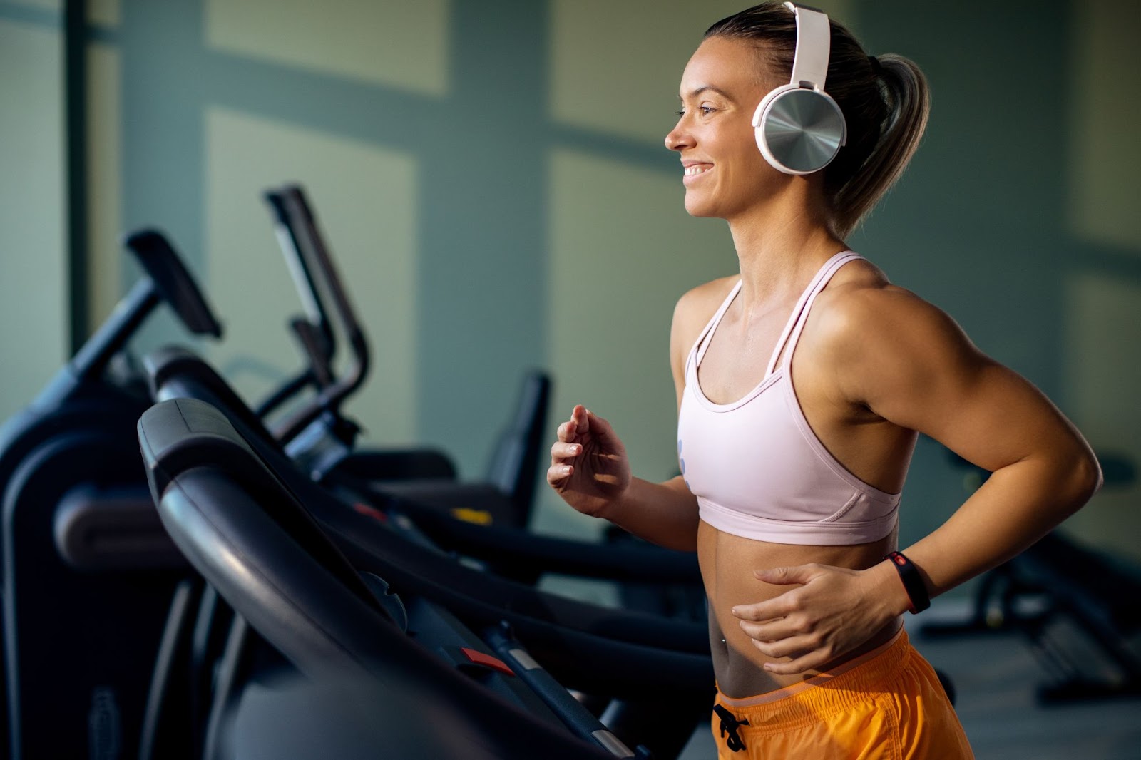 happy-female-athlete-running-treadmill-gym.jpg